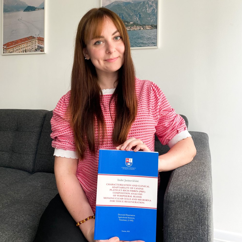 Dr. Indrė Matsuzaki holding her doctoral dissertation on canine platelet-rich fibrin